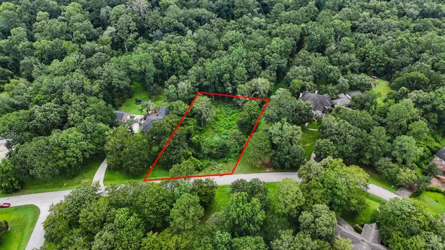 an aerial view of residential house with outdoor space and trees all around