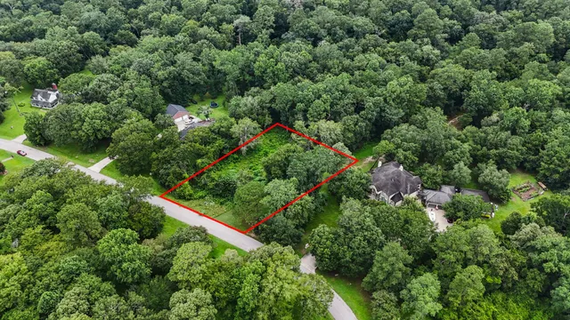 an aerial view of residential house with outdoor space and trees all around