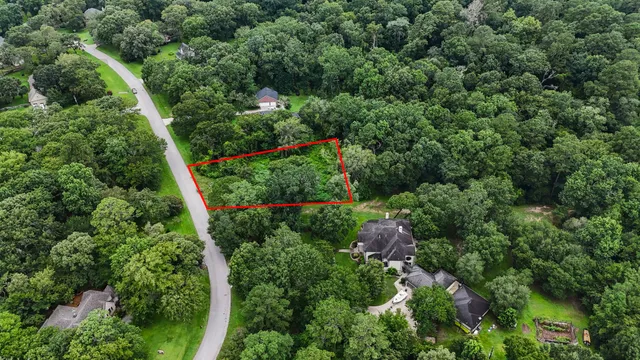 an aerial view of a house with a lush green forest