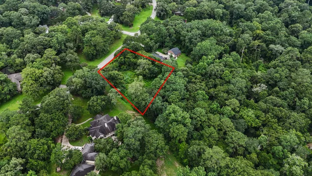 an aerial view of residential house with outdoor space and trees all around