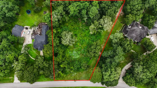 an aerial view of residential house with outdoor space and trees all around