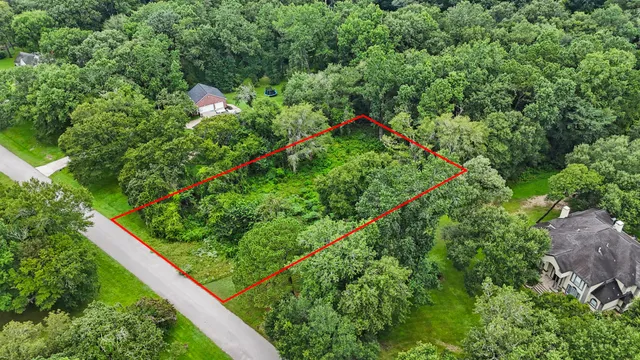an aerial view of residential house with outdoor space and trees all around