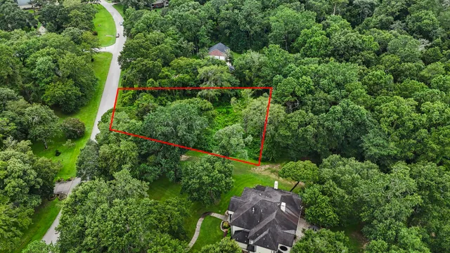an aerial view of residential house with outdoor space and trees all around
