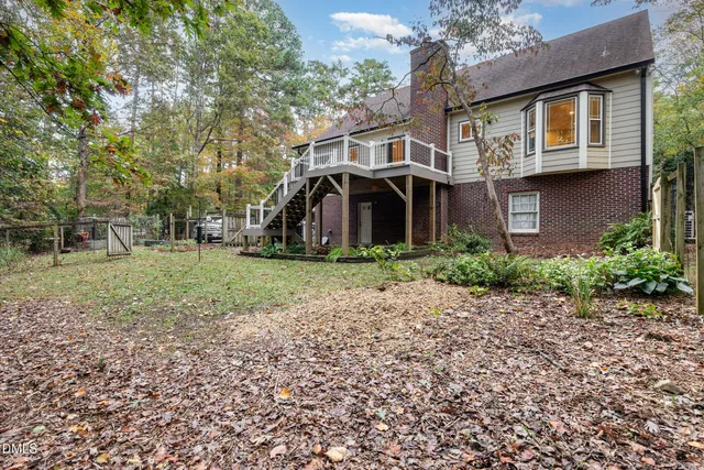 a view of a house with a yard and large trees
