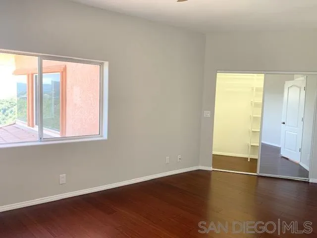 827 Mountain View Road El Cajon, CA 92021 - Photo 29 of 58 an empty room with wooden floor and windows