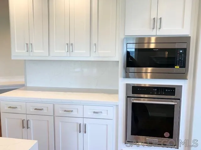 827 Mountain View Road El Cajon, CA 92021 - Photo 5 of 58 a kitchen with white cabinets and stainless steel appliances