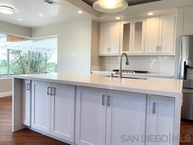 827 Mountain View Road El Cajon, CA 92021 - Photo 6 of 58 a kitchen with stainless steel appliances granite countertop a sink a window and white cabinets