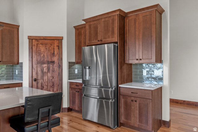 4221 Juniper Circle Alpine, UT 84004 - Photo 4 of 66 Gourmet kitchen featuring a stainless steel French door refrigerator, extensive wood cabinetry, light-toned countertops, and a tiled backsplash