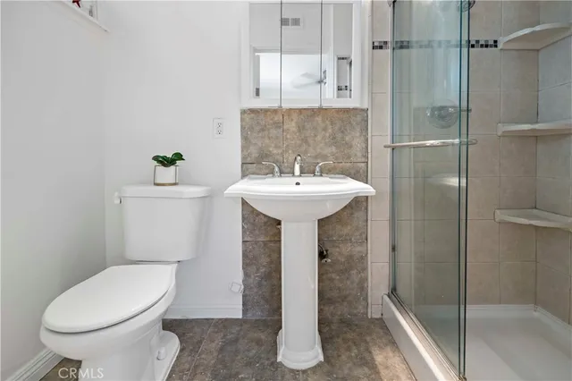 a bathroom with a sink toilet and shower
