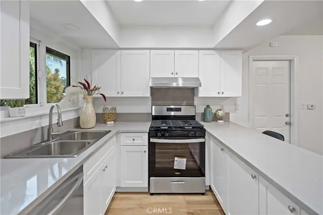a kitchen with sink a stove and cabinets