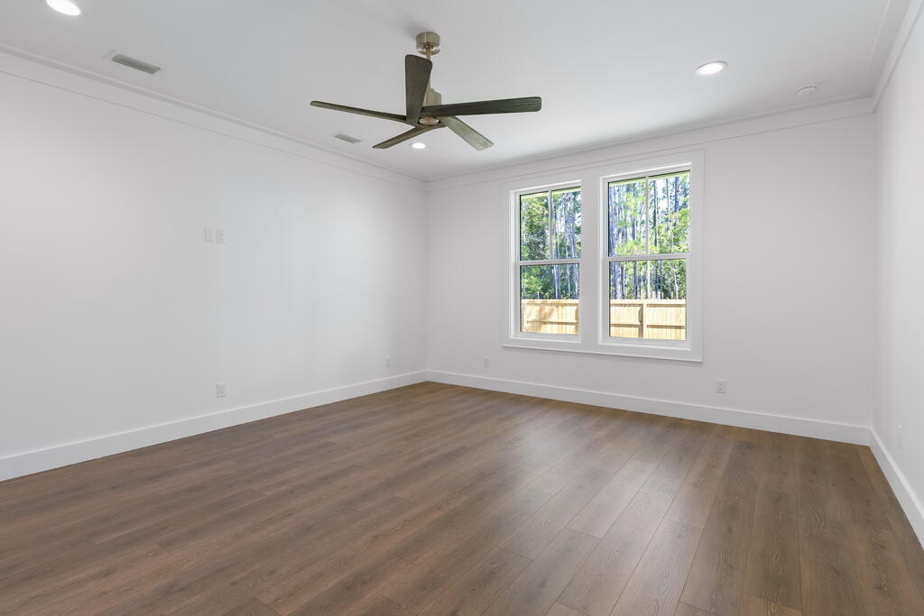 100 Grizzly Street Freeport, FL 32439 - Photo 17 of 65 a view of an empty room with wooden floor and a window