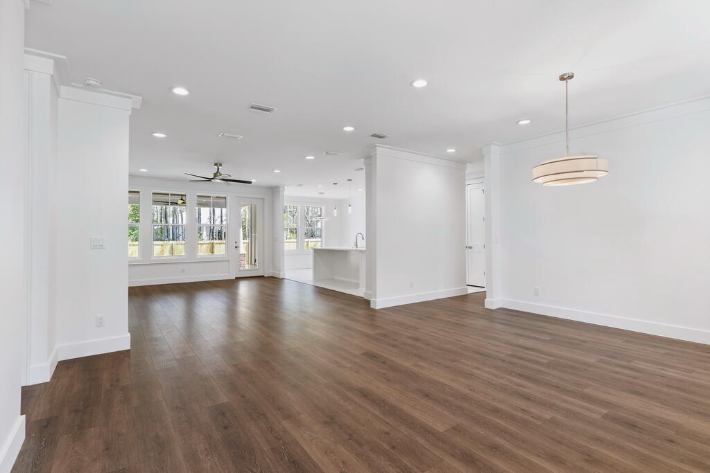 100 Grizzly Street Freeport, FL 32439 - Photo 20 of 65 a view of an empty room with wooden floor and a kitchen
