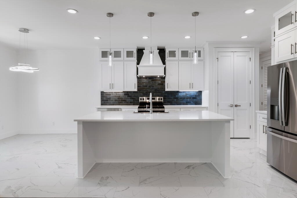 100 Grizzly Street Freeport, FL 32439 - Photo 3 of 65 a kitchen with kitchen island a counter top stainless steel appliances and cabinets