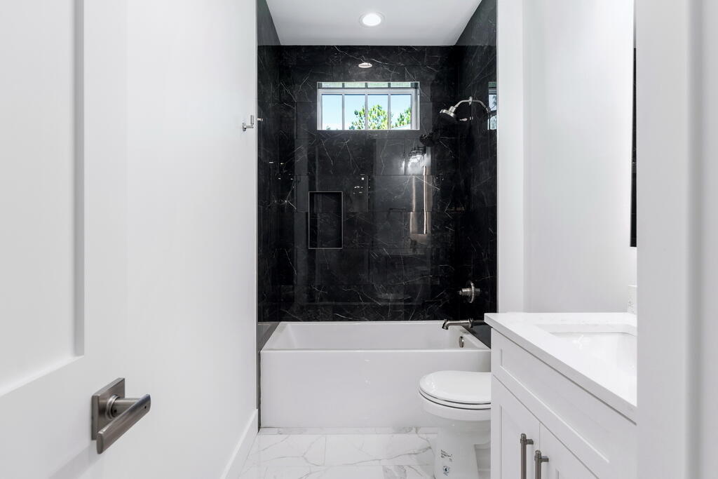 100 Grizzly Street Freeport, FL 32439 - Photo 36 of 65 a bathroom with a granite countertop bathtub shower sink vanity and toilet