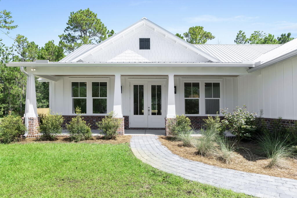 100 Grizzly Street Freeport, FL 32439 - Photo 46 of 65 a front view of a house with a yard and potted plants