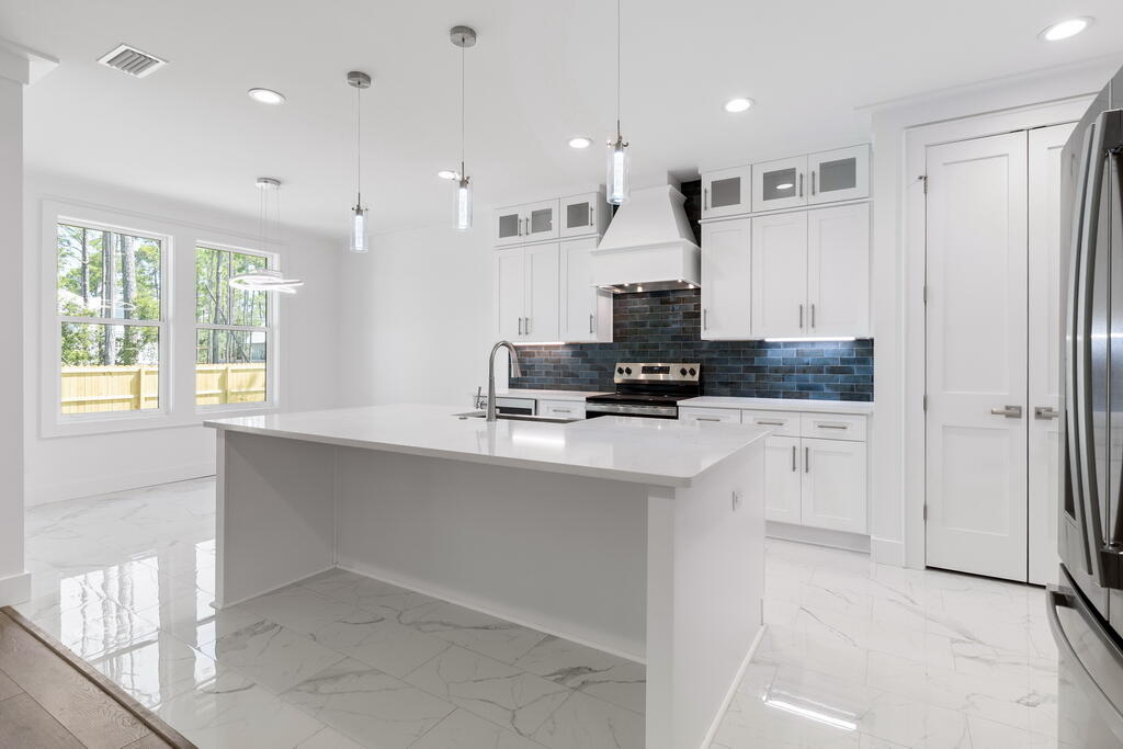 100 Grizzly Street Freeport, FL 32439 - Photo 5 of 65 a kitchen with kitchen island granite countertop a stove a sink and a refrigerator