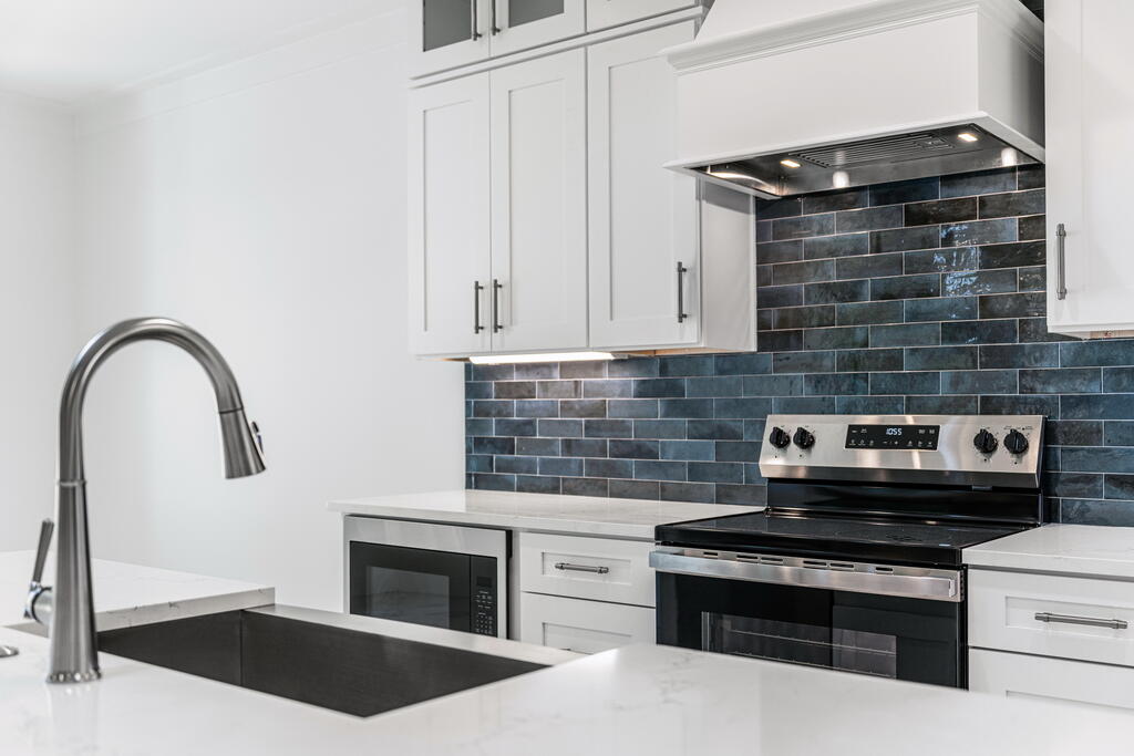 100 Grizzly Street Freeport, FL 32439 - Photo 8 of 65 a kitchen with a stove and white cabinets