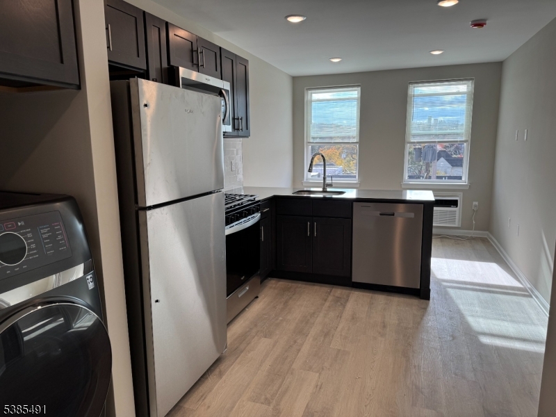 10 East Washington Avenue, Unit 301 Washington, NJ 07882 - Photo 2 of 5 a kitchen with stainless steel appliances granite countertop a refrigerator a sink a stove and island