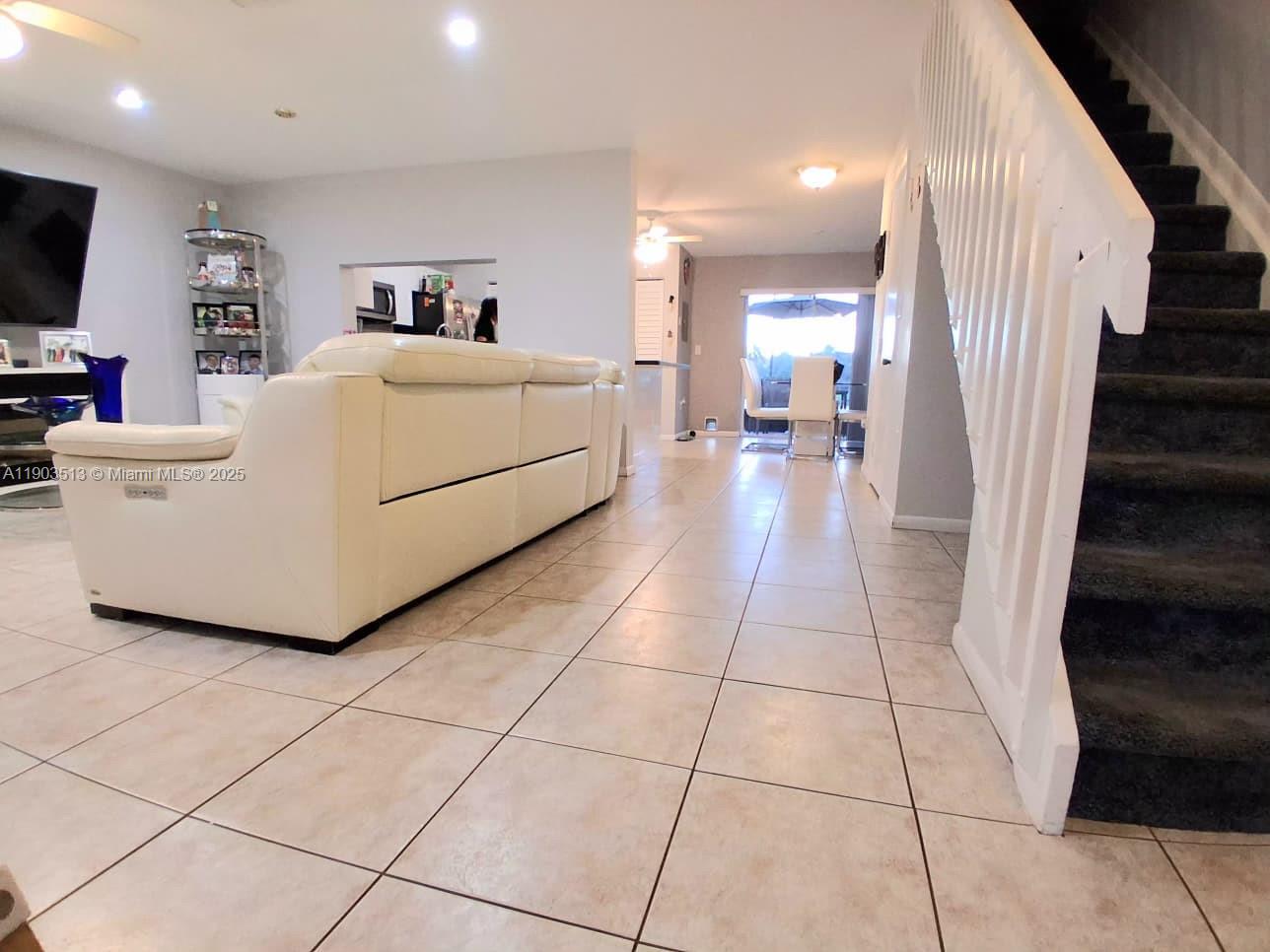 10830 Northwest 8th Street Pembroke Pines, FL 33026 - Photo 11 of 69 a living room with a couch and a flat screen tv