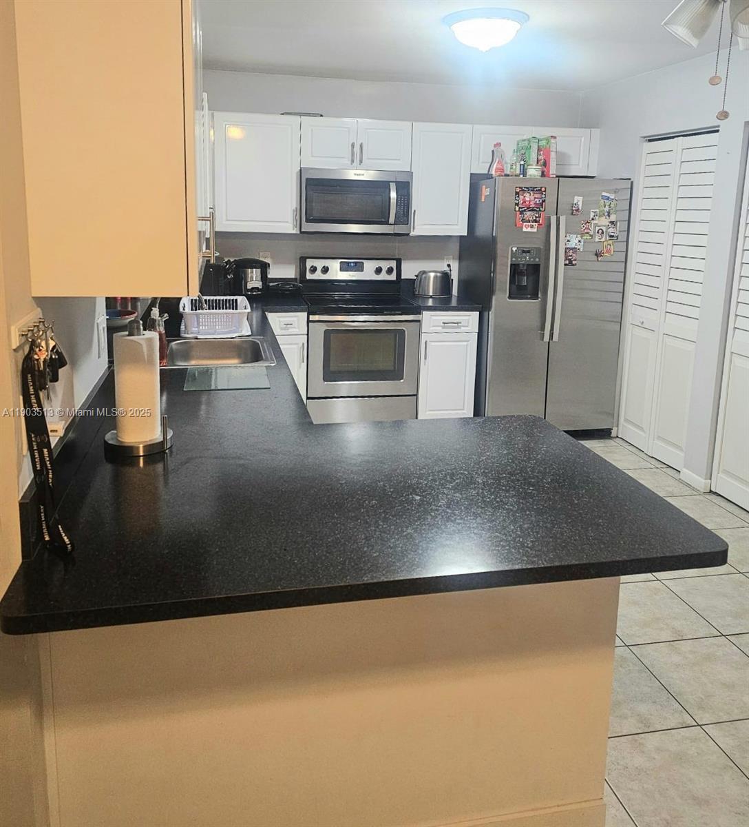 10830 Northwest 8th Street Pembroke Pines, FL 33026 - Photo 19 of 69 a kitchen with stainless steel appliances granite countertop a refrigerator a stove and a sink with wooden floor