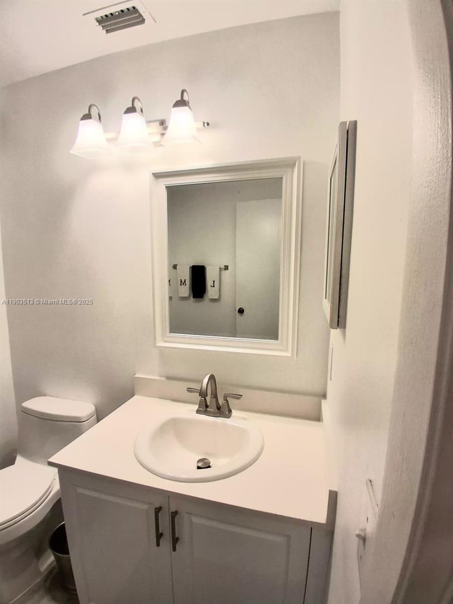10830 Northwest 8th Street Pembroke Pines, FL 33026 - Photo 25 of 69 a bathroom with a sink a toilet and mirror