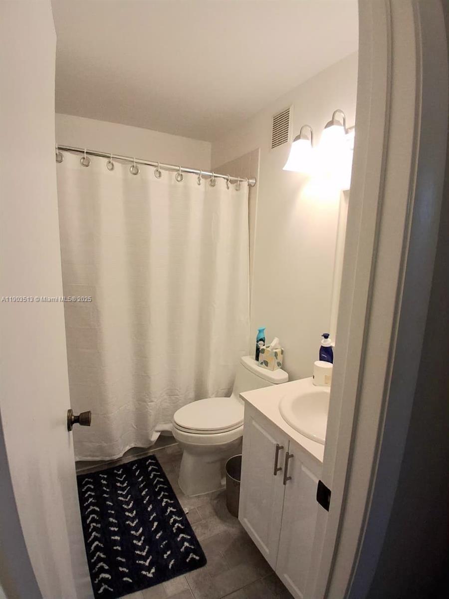 10830 Northwest 8th Street Pembroke Pines, FL 33026 - Photo 32 of 69 a bathroom with a sink a toilet a shower curtain and a mirror