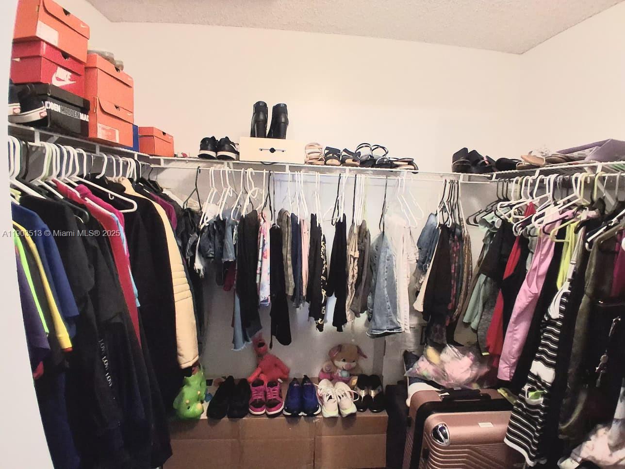 10830 Northwest 8th Street Pembroke Pines, FL 33026 - Photo 38 of 69 a view of walk in closet with clothes and shoes