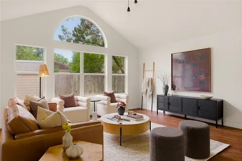 a living room with furniture a large window and a chandelier