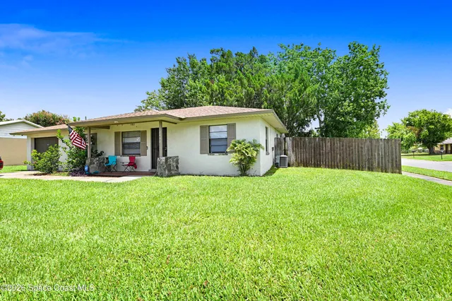 a view of a house with backyard and a garden