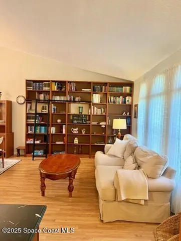 a view of a bedroom with wooden floor and ceiling fan