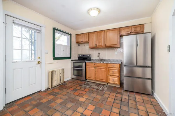 a kitchen with granite countertop a refrigerator stove top oven and sink
