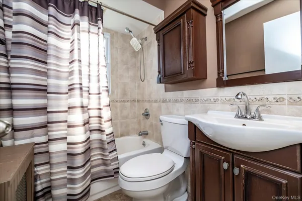 a bathroom with a sink a toilet and shower curtain