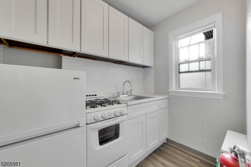 495 Main Street, Unit B 2 Chatham, NJ 07928 - Photo 3 of 22 a kitchen with granite countertop white cabinets and white appliances