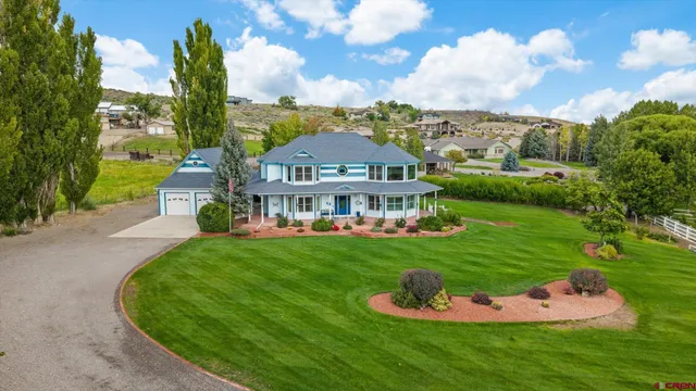 a front view of a house with a garden and trees