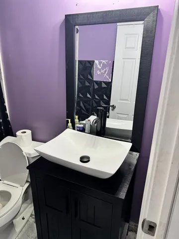 a bathroom with a sink a toilet and mirror