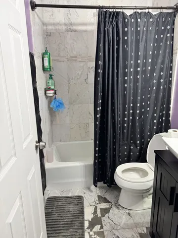 a bathroom with a toilet and a shower