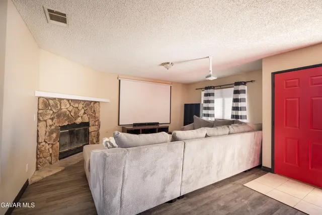 a living room with furniture a fireplace and a flat screen tv