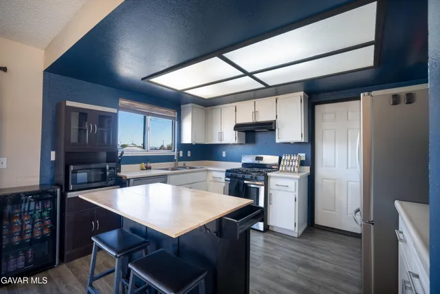 a kitchen with stainless steel appliances wooden floor dining table and chairs