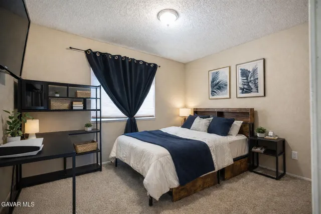 a bedroom with a bed a couch and a potted plant