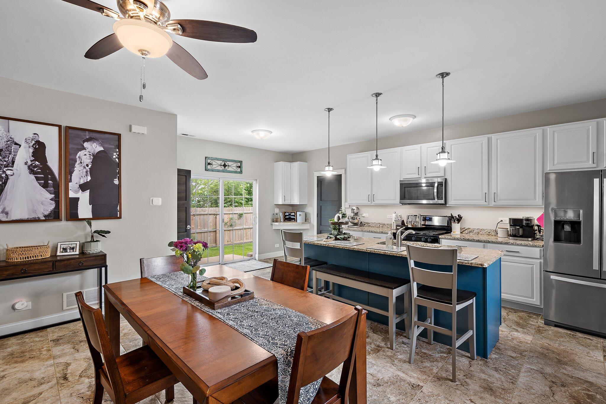 105 Madison Street Valparaiso, IN 46385 - Photo 4 of 29 a kitchen with stainless steel appliances granite countertop a stove a refrigerator a kitchen island a dining table and chairs with wooden floor