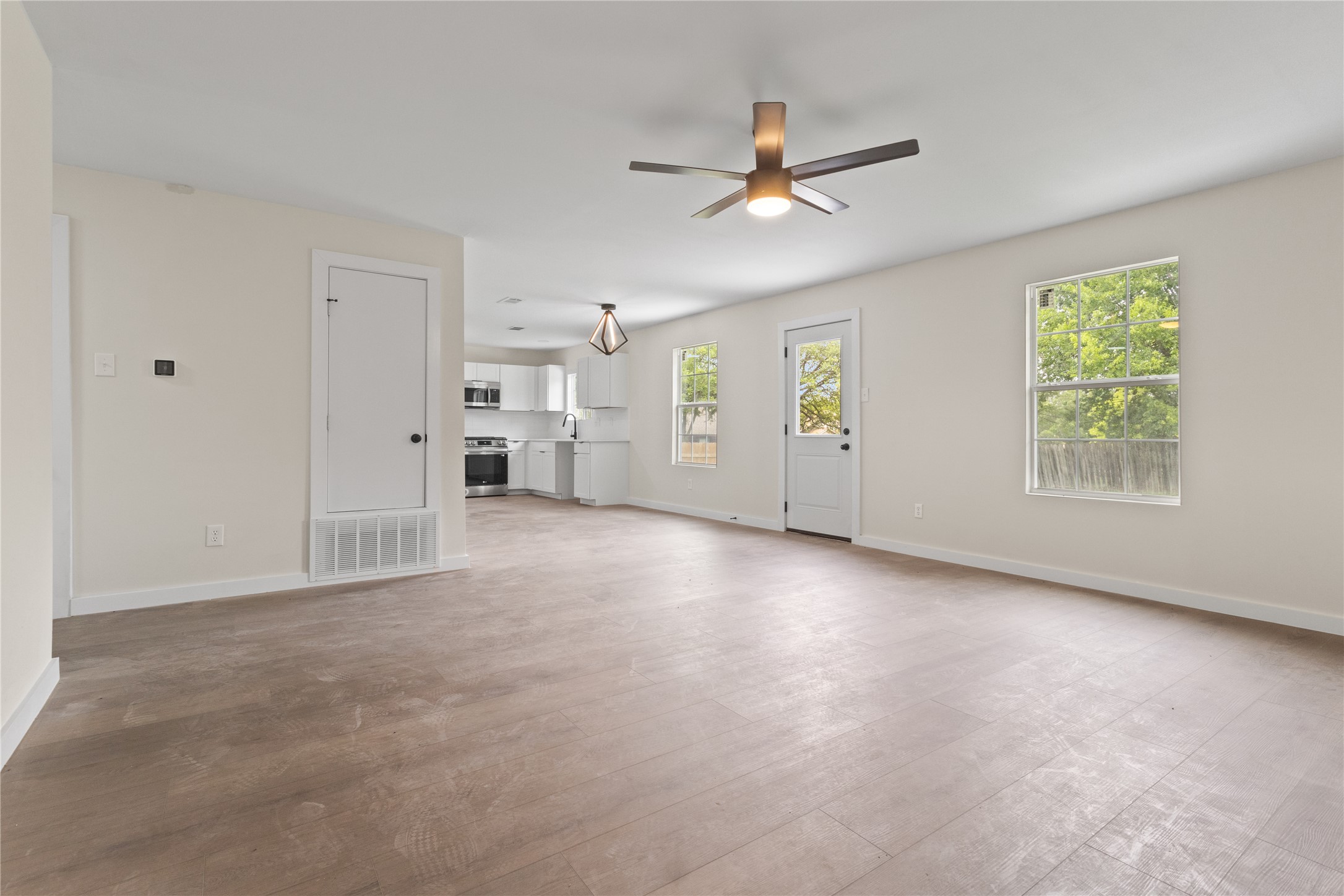 8528 Cornwall Drive Austin, TX 78748 - Photo 4 of 24 Unfurnished living room with ceiling fan, light wood-style floors, and baseboards