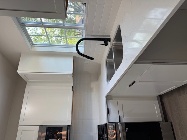 8528 Cornwall Drive Austin, TX 78748 - Photo 8 of 24 Kitchen with range, a sink, backsplash, light stone counters, and dark wood-style floors