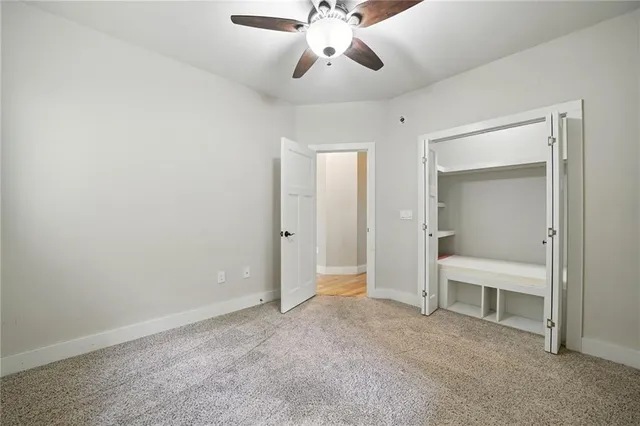 a view of an empty room with chandelier fan