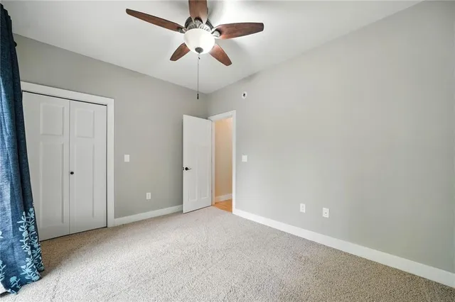 an empty room with a chandelier fan and a ceiling fan