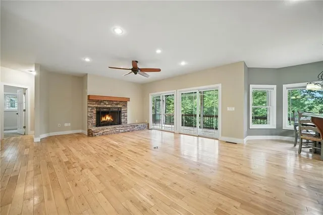 a view of empty room with wooden floor and fireplace