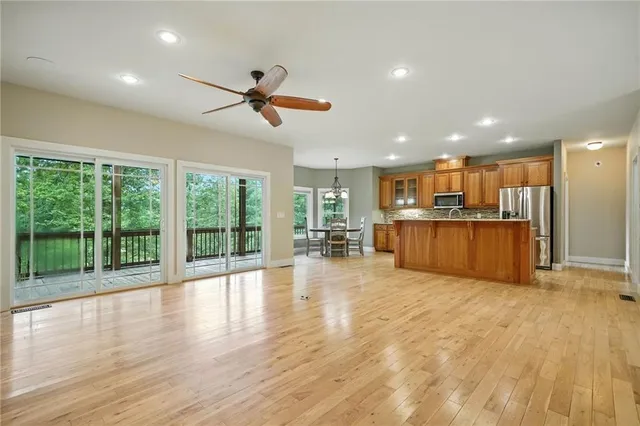 a view of a big room with wooden floor and windows
