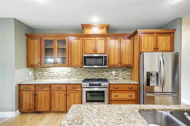a kitchen with stainless steel appliances granite countertop a stove sink and refrigerator