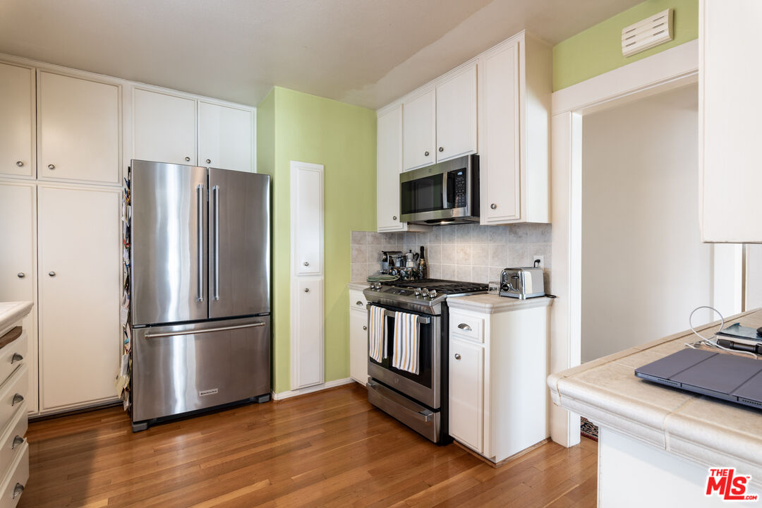 880 Wellesley Avenue Los Angeles, CA 90049 - Photo 12 of 29 a kitchen with stainless steel appliances granite countertop a refrigerator stove and microwave