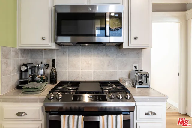 a stove top oven sitting inside of a kitchen