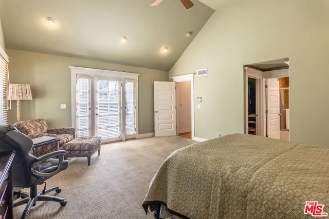 a spacious bedroom with a bed a table and chair